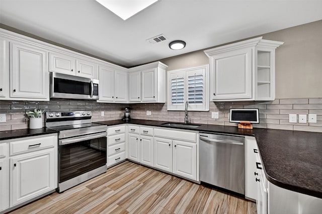 218 Bryant St, Pottsboro, TX 75076 - kitchen with appliances with stainless steel finishes, white cabinets, dark countertops, and backsplash