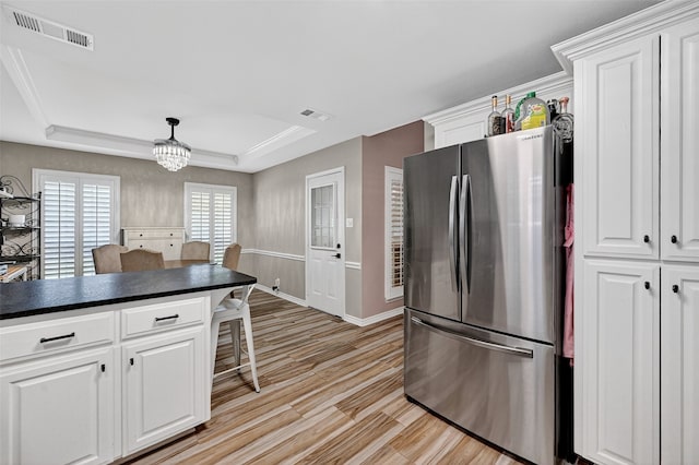 218 Bryant St, Pottsboro, TX 75076 - kitchen with freestanding refrigerator, a tray ceiling, a kitchen bar, dark countertops, and white cabinets