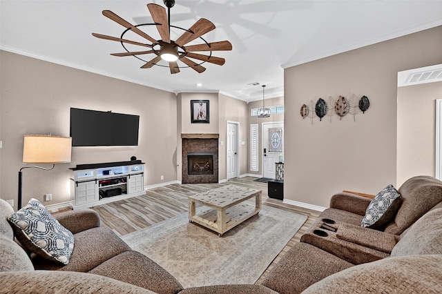 218 Bryant St, Pottsboro, TX 75076 - living room with a ceiling fan, crown molding, wood finished floors, recessed lighting, and a tiled fireplace