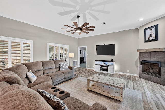 218 Bryant St, Pottsboro, TX 75076 - living area with ceiling fan, crown molding, wood finished floors, a tiled fireplace, and recessed lighting