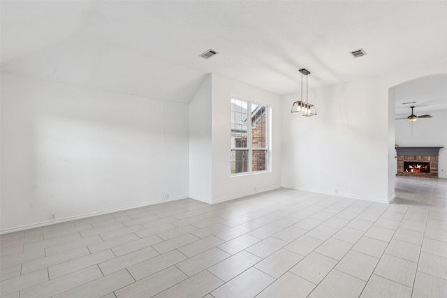 10412 Harris Ct, Irving, TX 75063 - spare room featuring ceiling fan, a brick fireplace, lofted ceiling, arched walkways, and light tile patterned floors