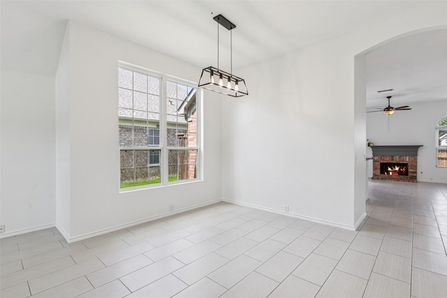 10412 Harris Ct, Irving, TX 75063 - unfurnished dining area with plenty of natural light, ceiling fan, arched walkways, and a fireplace