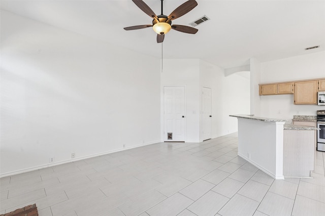 10412 Harris Ct, Irving, TX 75063 - kitchen with a ceiling fan, stainless steel microwave, electric range, light stone countertops, and open floor plan