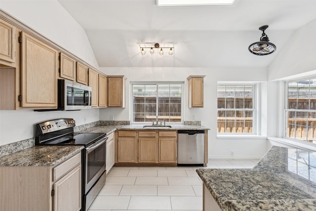 10412 Harris Ct, Irving, TX 75063 - kitchen with stainless steel appliances, lofted ceiling, light tile patterned floors, and dark stone countertops