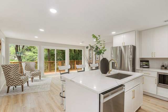 2155 Hickory Trce, Mabank, TX 75156 - kitchen with appliances with stainless steel finishes, plenty of natural light, light wood finished floors, light stone counters, and recessed lighting