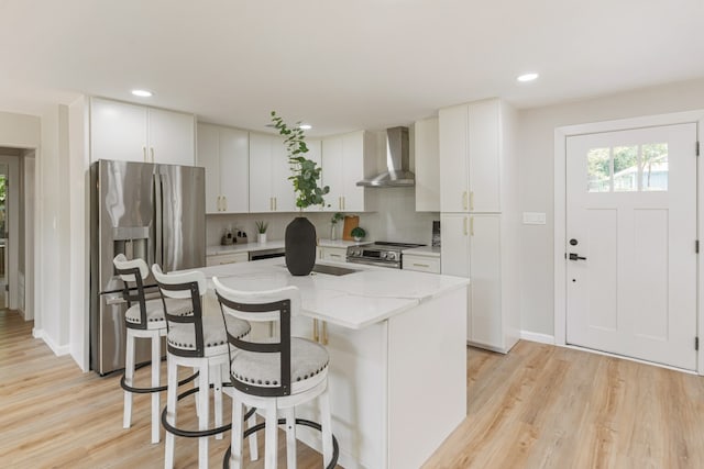 2155 Hickory Trce, Mabank, TX 75156 - kitchen featuring wall chimney exhaust hood, stainless steel appliances, a kitchen island, tasteful backsplash, and a breakfast bar area