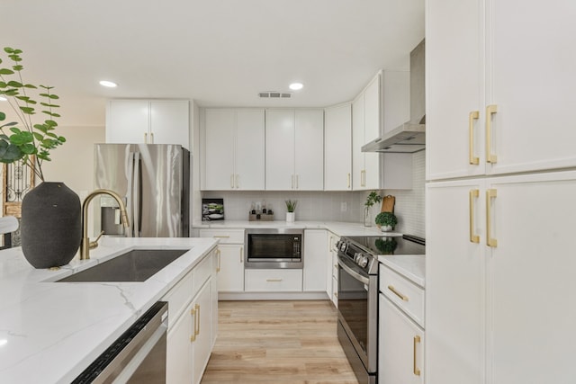 2155 Hickory Trce, Mabank, TX 75156 - kitchen with stainless steel appliances, wall chimney exhaust hood, light stone countertops, white cabinets, and recessed lighting