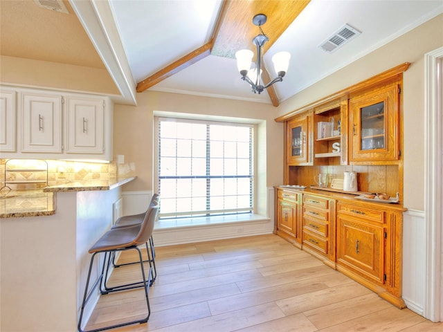 2219 Timberwood, Carrollton, TX 75006 - kitchen featuring backsplash, a chandelier, light wood-style flooring, light stone countertops, and crown molding