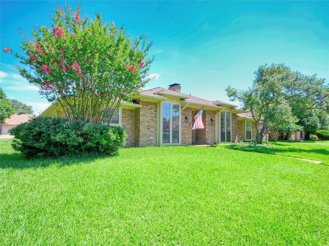 2219 Timberwood, Carrollton, TX 75006 - view of front facade featuring a front yard, a chimney, and brick siding