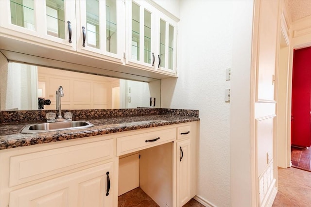 1115 Shady Oak Trl, Mansfield, TX 76063 - kitchen featuring light tile patterned floors, glass insert cabinets, and dark stone counters