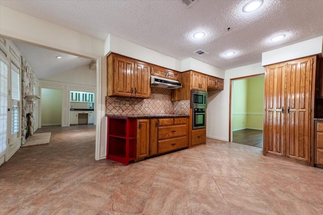 1115 Shady Oak Trl, Mansfield, TX 76063 - kitchen featuring stainless steel appliances, under cabinet range hood, dark countertops, backsplash, and brown cabinetry