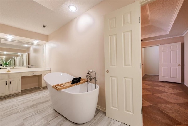 1115 Shady Oak Trl, Mansfield, TX 76063 - bathroom with vanity, a freestanding tub, a textured ceiling, ornamental molding, and a tray ceiling