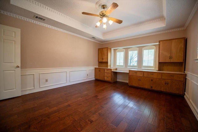 1115 Shady Oak Trl, Mansfield, TX 76063 - empty room with a raised ceiling, ceiling fan, crown molding, dark wood finished floors, and a decorative wall