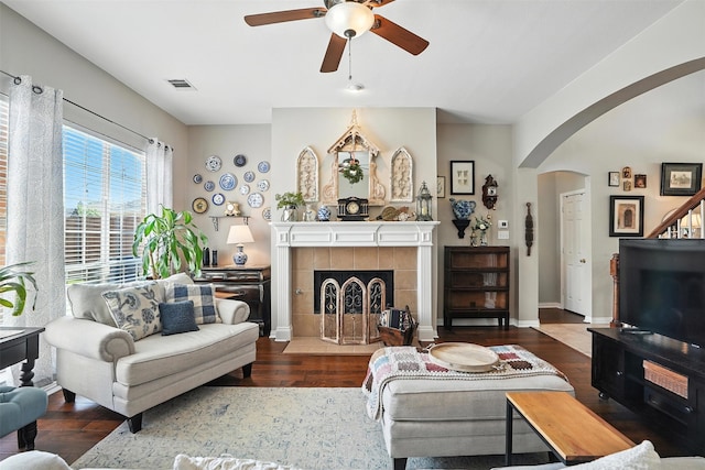 2040 Chisholm Trl, Frisco, TX 75033 - living area with a ceiling fan, wood finished floors, arched walkways, and a tiled fireplace