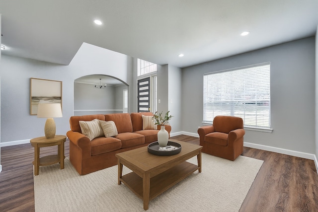 7851 Quiet Meadow Ln, Frisco, TX 75033 - living area featuring healthy amount of natural light, wood finished floors, arched walkways, recessed lighting, and a chandelier