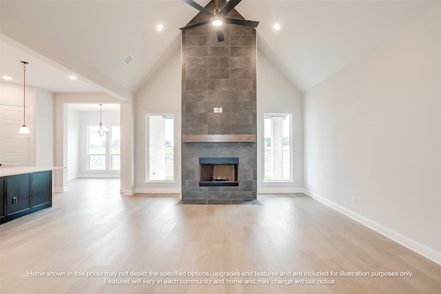 230 Olson Rd, Waxahachie, TX 75167 - unfurnished living room with high vaulted ceiling, light wood-type flooring, a tile fireplace, a ceiling fan, and recessed lighting