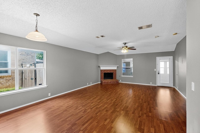 8409 Vicksburg Ln, Fort Worth, TX 76123 - unfurnished living room featuring a textured ceiling, wood finished floors, ceiling fan, and a fireplace