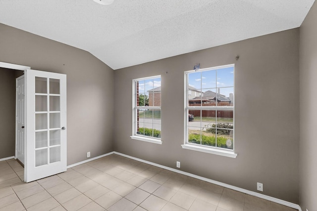 8409 Vicksburg Ln, Fort Worth, TX 76123 - unfurnished room with healthy amount of natural light, light tile patterned flooring, lofted ceiling, and a textured ceiling