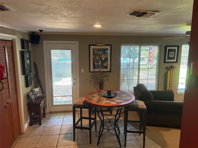 625 N Bailey Ave, Fort Worth, TX 76107 - dining space with ornamental molding, plenty of natural light, a textured ceiling, and light tile patterned flooring