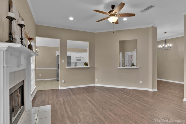 144 Arbor Ln, Shreveport, LA 71115 - unfurnished living room with ceiling fan, wood finished floors, a tile fireplace, ornamental molding, and a chandelier