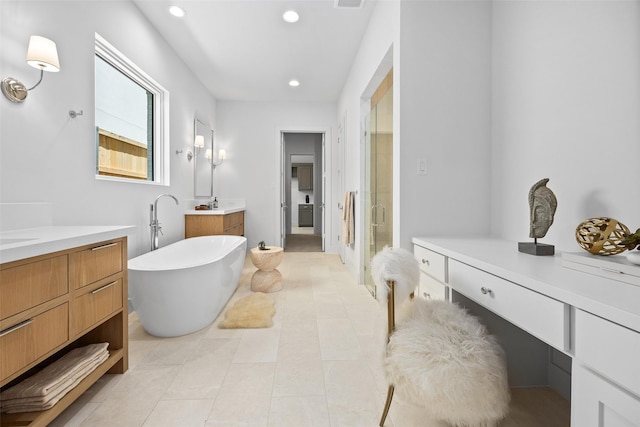 7523 Robin Rd, Dallas, TX 75209 - bathroom featuring a shower stall, two vanities, a freestanding tub, recessed lighting, and tile patterned flooring