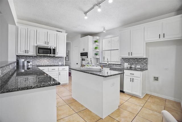 401 Wolverley Ln, Allen, TX 75002 - kitchen with stainless steel appliances, open shelves, backsplash, dark stone countertops, and a textured ceiling