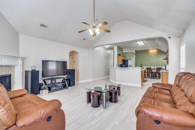 7012 Hillshire Ln, Sachse, TX 75048 - living area with arched walkways, lofted ceiling, a ceiling fan, and a fireplace