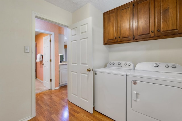 2815 Whisperwood Trl, Dalworthington Gardens, TX 76016 - laundry area with cabinet space, washing machine and clothes dryer, and light wood-style flooring