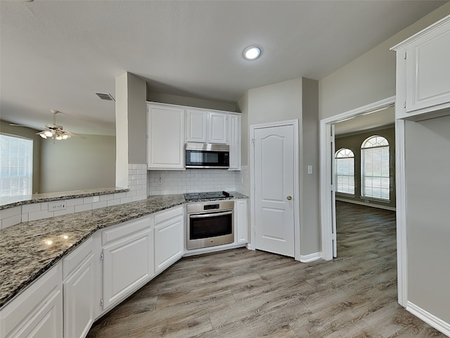 2829 Alcot Ln, Grand Prairie, TX 75052 - kitchen with stainless steel appliances, light stone countertops, decorative backsplash, white cabinetry, and ceiling fan