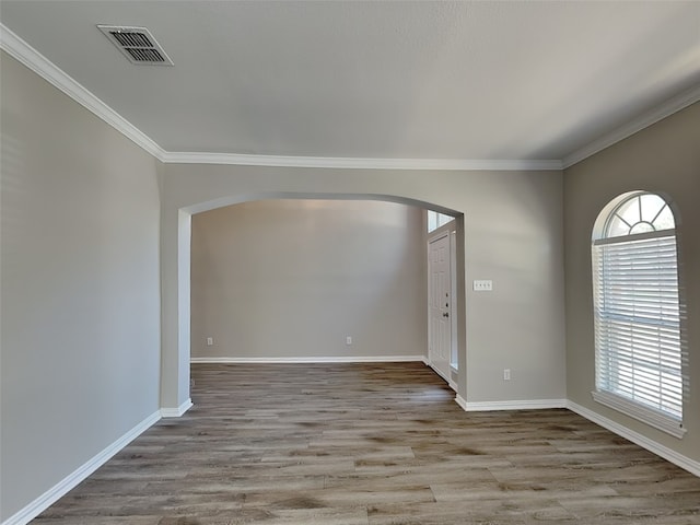 2829 Alcot Ln, Grand Prairie, TX 75052 - spare room with arched walkways, healthy amount of natural light, wood finished floors, and crown molding