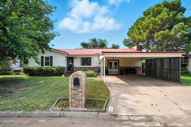 1017 2nd St, Hamlin, TX 79520 - ranch-style house with french doors, driveway, a front lawn, a metal roof, and a carport