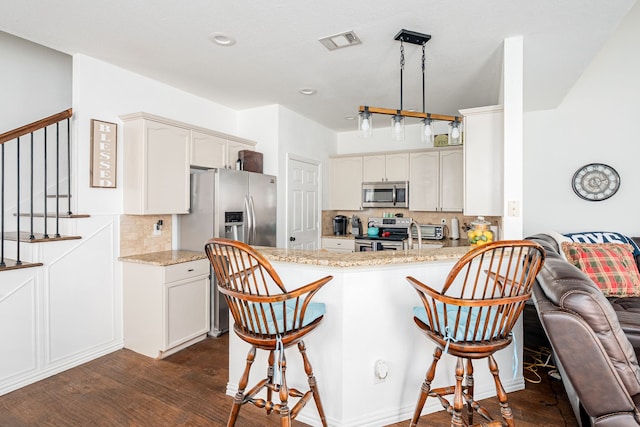 11116 Elizabeth Ave, Frisco, TX 75035 - kitchen featuring stainless steel appliances, tasteful backsplash, dark wood-type flooring, a breakfast bar, and recessed lighting