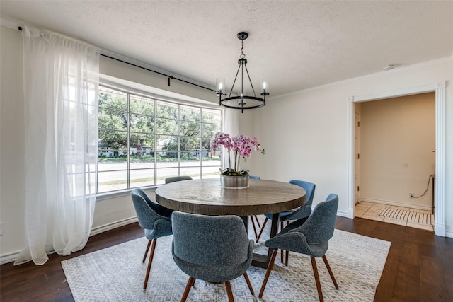 6342 E Lovers Ln, Dallas, TX 75214 - dining space with a chandelier, a textured ceiling, dark wood finished floors, and ornamental molding