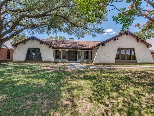 1425 Meyers Rd, Irving, TX 75060 - view of front of property with a chimney, a front lawn, a tiled roof, and stucco siding