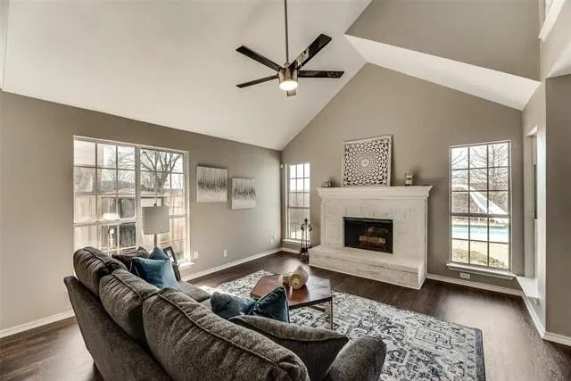4914 Redwater Dr, Arlington, TX 76018 - living room featuring a ceiling fan, dark wood-style flooring, a fireplace, and high vaulted ceiling