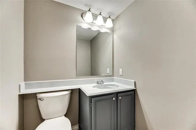 4914 Redwater Dr, Arlington, TX 76018 - half bathroom featuring vanity and toilet