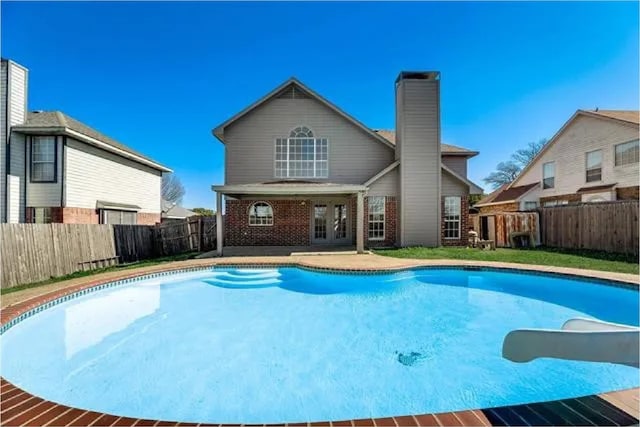 4914 Redwater Dr, Arlington, TX 76018 - view of pool with french doors, a water slide, and a fenced backyard