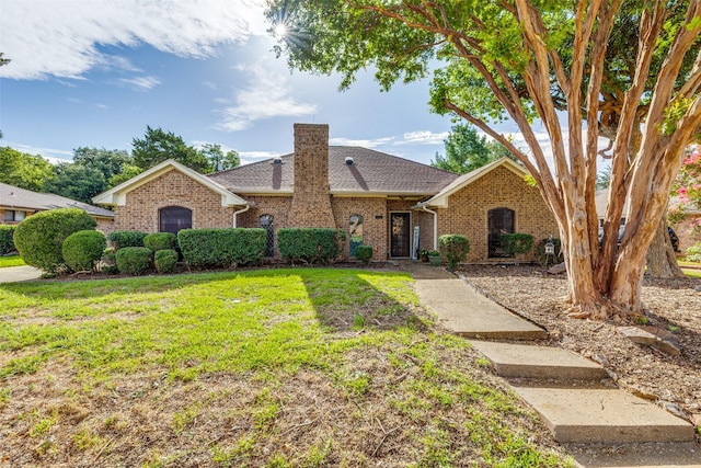 128 Timber Ridge Dr, Murphy, TX 75094 - view of front of home featuring a front yard, a chimney, brick siding, and a shingled roof