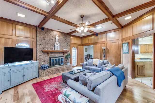 128 Timber Ridge Dr, Murphy, TX 75094 - living room featuring a ceiling fan, beamed ceiling, a textured ceiling, light wood-type flooring, and a fireplace