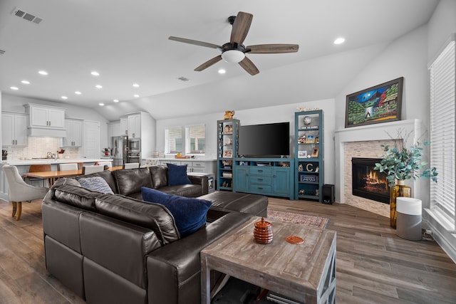3700 Blue Stream Dr, Little Elm, TX 75068 - living room with lofted ceiling, ceiling fan, wood finished floors, recessed lighting, and a glass covered fireplace