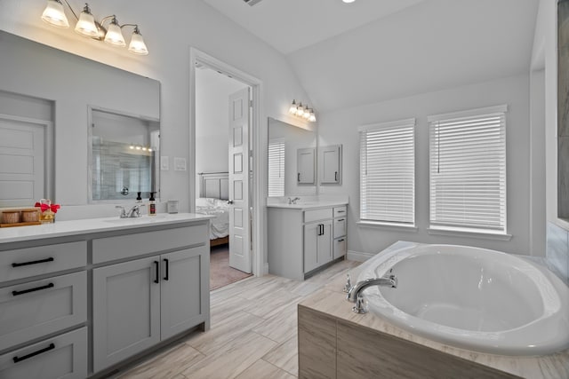 3700 Blue Stream Dr, Little Elm, TX 75068 - bathroom with vaulted ceiling, two vanities, a garden tub, and a shower with shower door