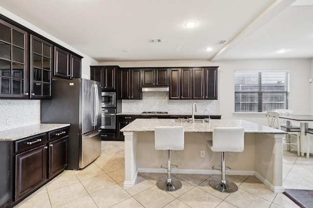 1009 Chickasaw Dr, Carrollton, TX 75010 - kitchen featuring appliances with stainless steel finishes, decorative backsplash, a kitchen bar, light tile patterned floors, and recessed lighting
