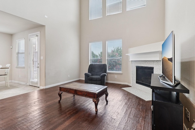 1009 Chickasaw Dr, Carrollton, TX 75010 - living room featuring a high ceiling, healthy amount of natural light, wood finished floors, and a tiled fireplace