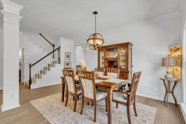3252 Shady Glen Dr, Grapevine, TX 76051 - dining room with stairs, a textured ceiling, light wood-type flooring, a chandelier, and crown molding