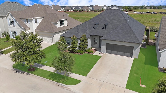 712 Tallgrass Dr, Aledo, TX 76008 - french provincial home featuring an attached garage, driveway, roof with shingles, a residential view, and a front yard