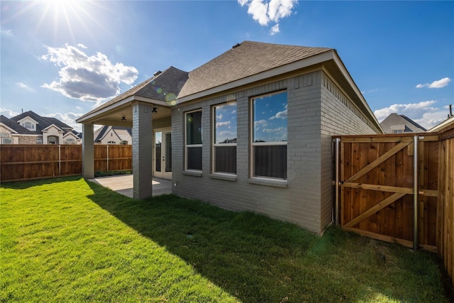 2402 Amesbury Dr, Midlothian, TX 76065 - back of house with a patio, brick siding, roof with shingles, and a gate