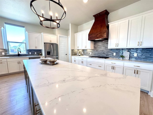 2402 Amesbury Dr, Midlothian, TX 76065 - kitchen with appliances with stainless steel finishes, premium range hood, a center island, and a chandelier