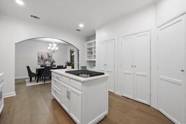 2800 Broadacres Ln, Dalworthington Gardens, TX 76016 - kitchen with arched walkways, stainless steel gas stovetop, a chandelier, ornamental molding, and white cabinetry