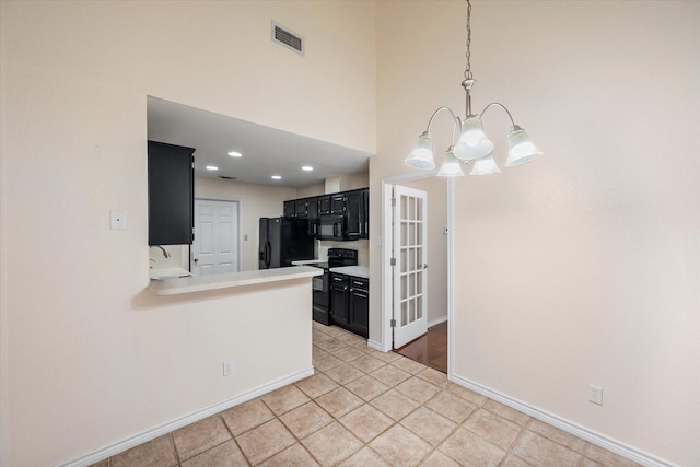 4056 La Costa Ct, Irving, TX 75038 - kitchen featuring a chandelier, dark cabinetry, black appliances, light countertops, and a towering ceiling
