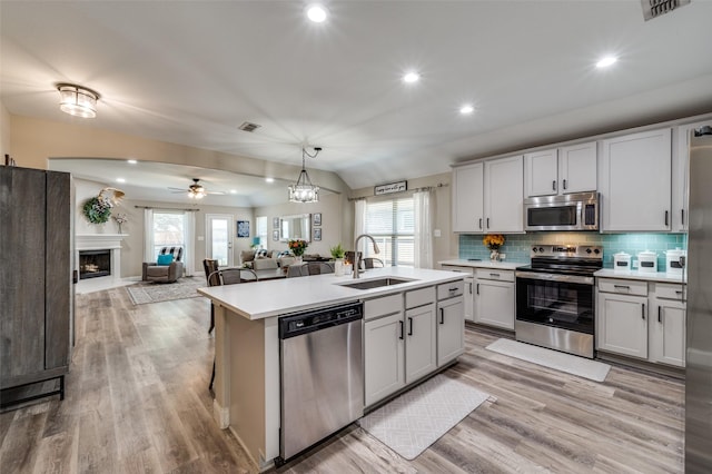 1289 Lasso Dr, Little Elm, TX 75068 - kitchen featuring stainless steel appliances, light countertops, a ceiling fan, light wood-style flooring, and backsplash